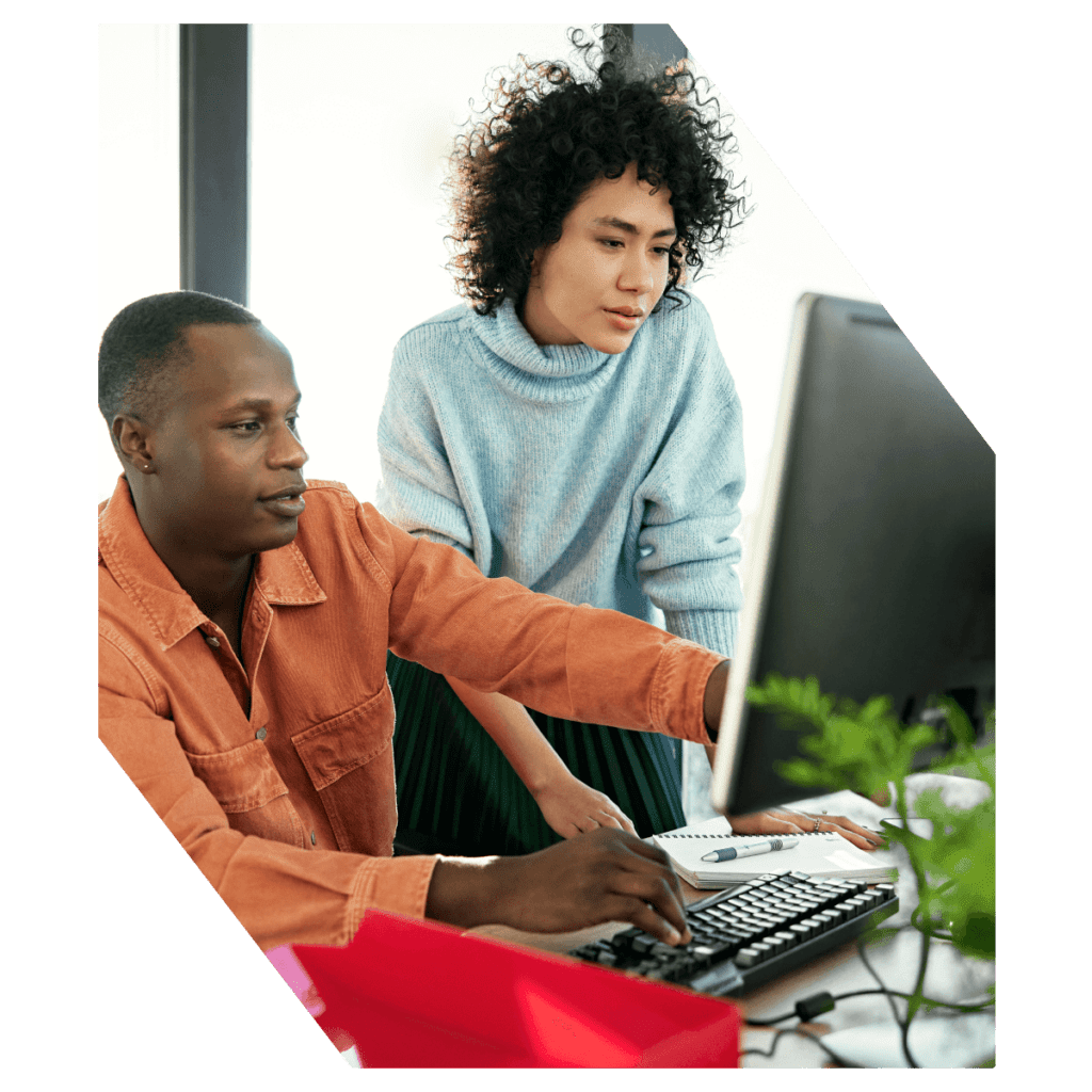 Man and woman looking over desktop computer