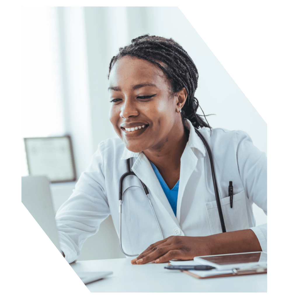 Doctor smiling while working on laptop